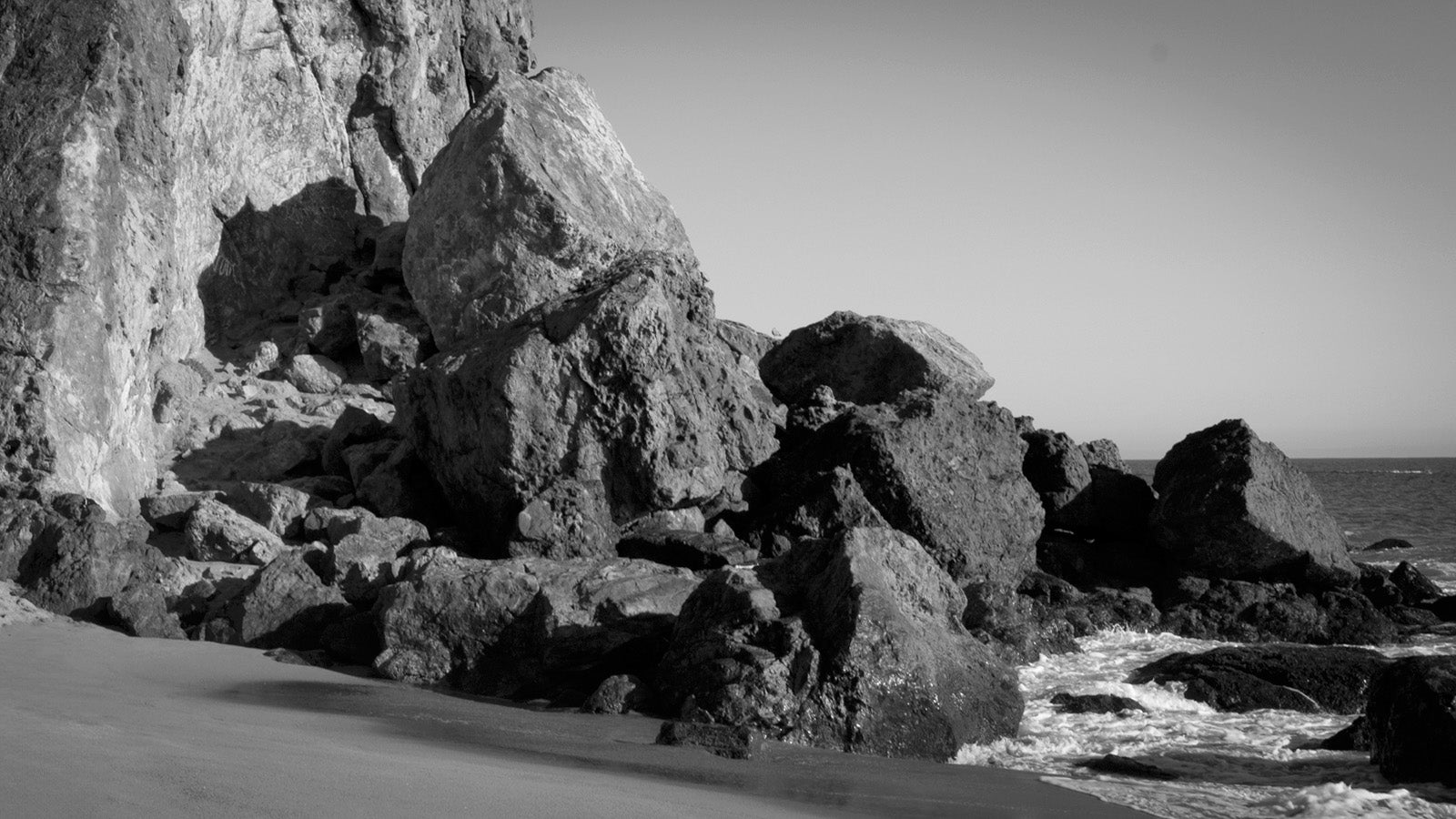 Rocks on a beach with ocean waves in the background