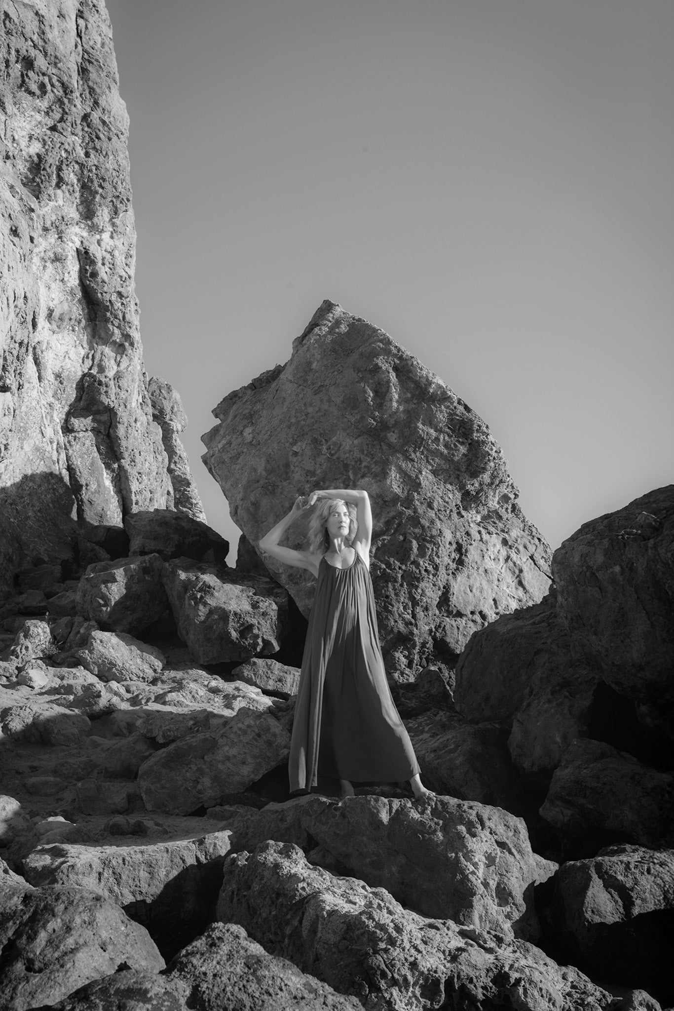 Avarra Magnesium Oil model in a long dress standing on rocky terrain