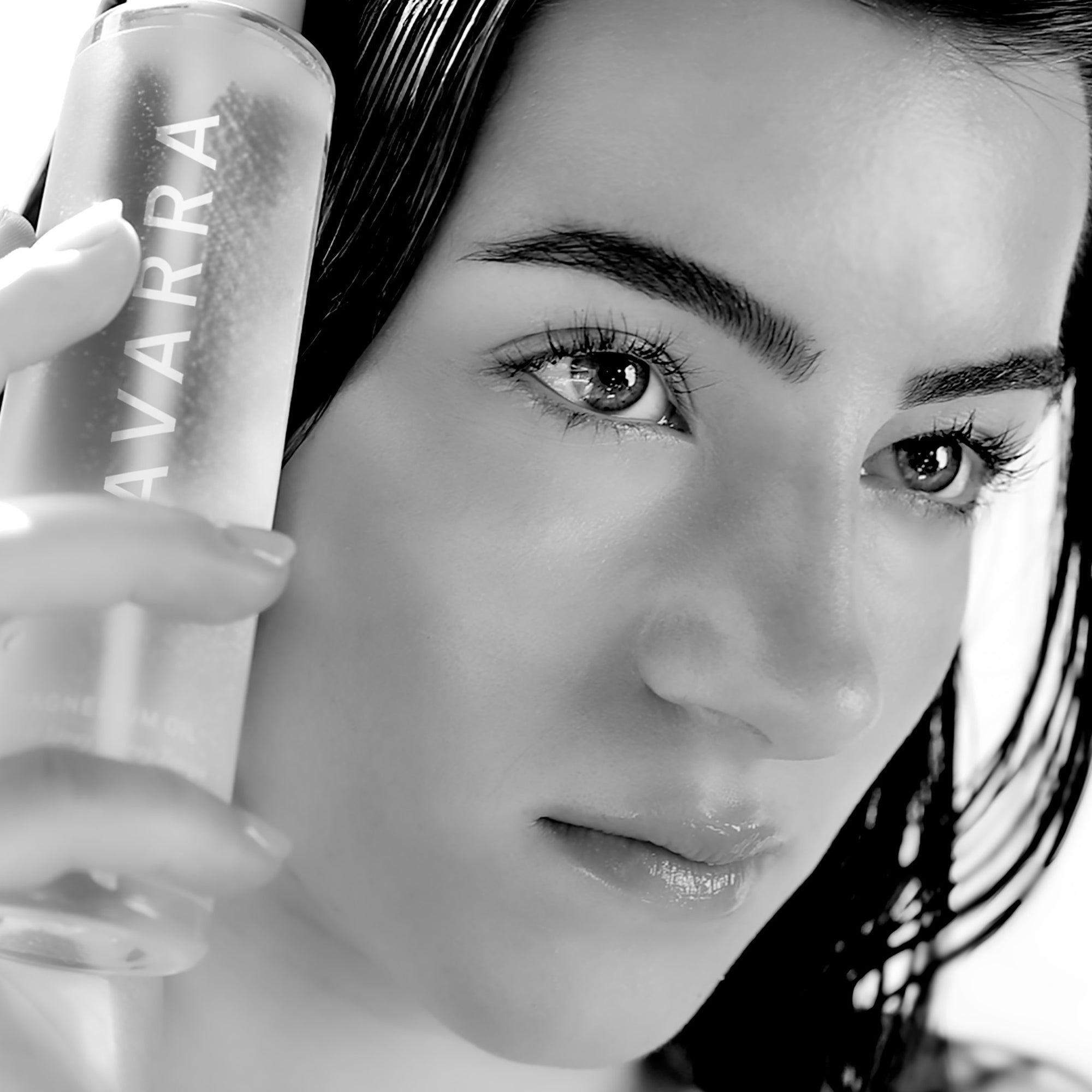 Person holding a bottle labeled AVARRA with a close-up of their face.